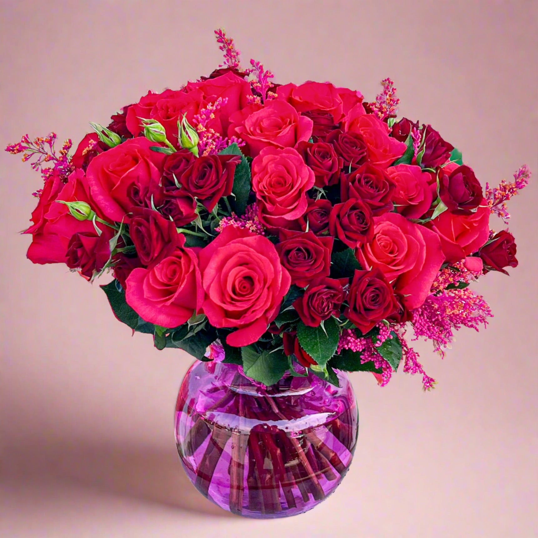 A vase filled with vibrant red roses and purple flowers, showcasing a beautiful Vase Flower Arrangements