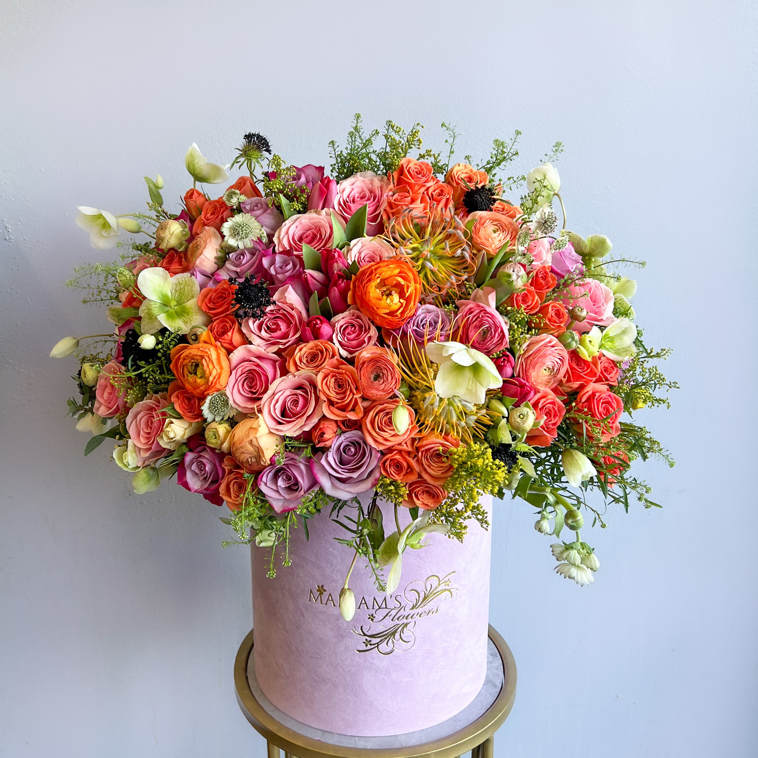 A large pink box filled with a vibrant assortment of flowers, embodying the essence of springtime beauty