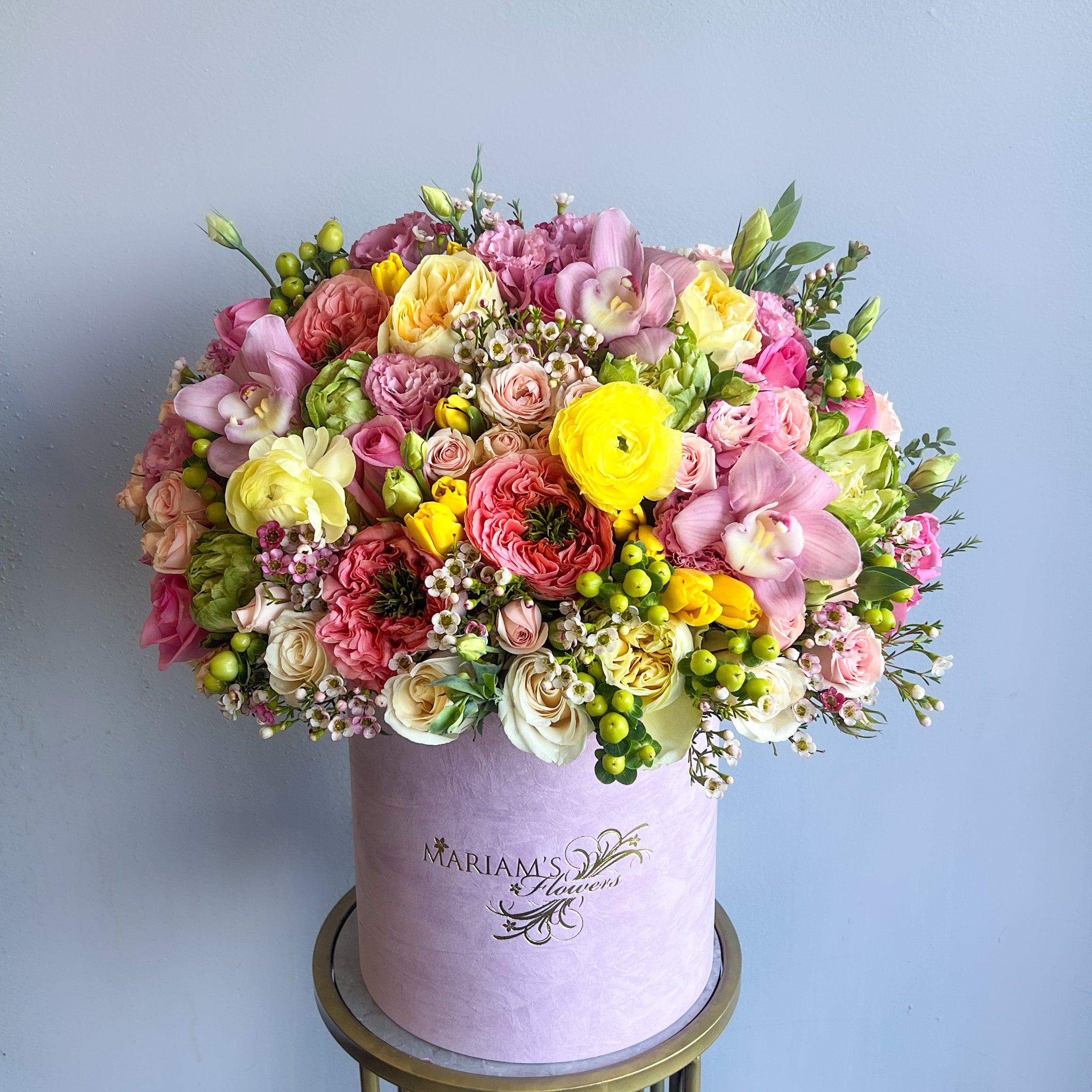 A large pink flower box filled with vibrant yellow and pink flowers, embodying the essence of spring bliss