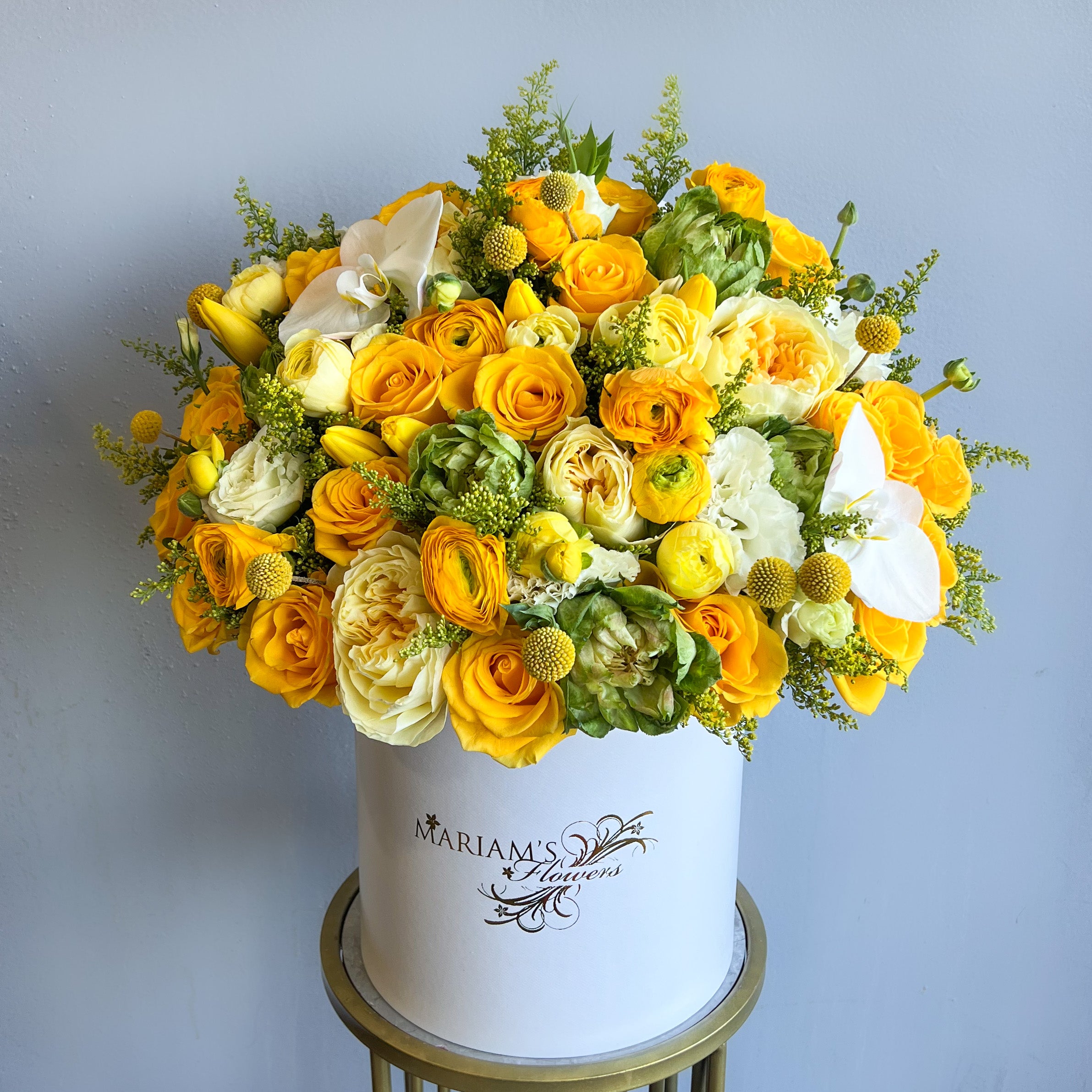 Elegant white box filled with cheerful yellow and white flowers, creating a stunning floral display.