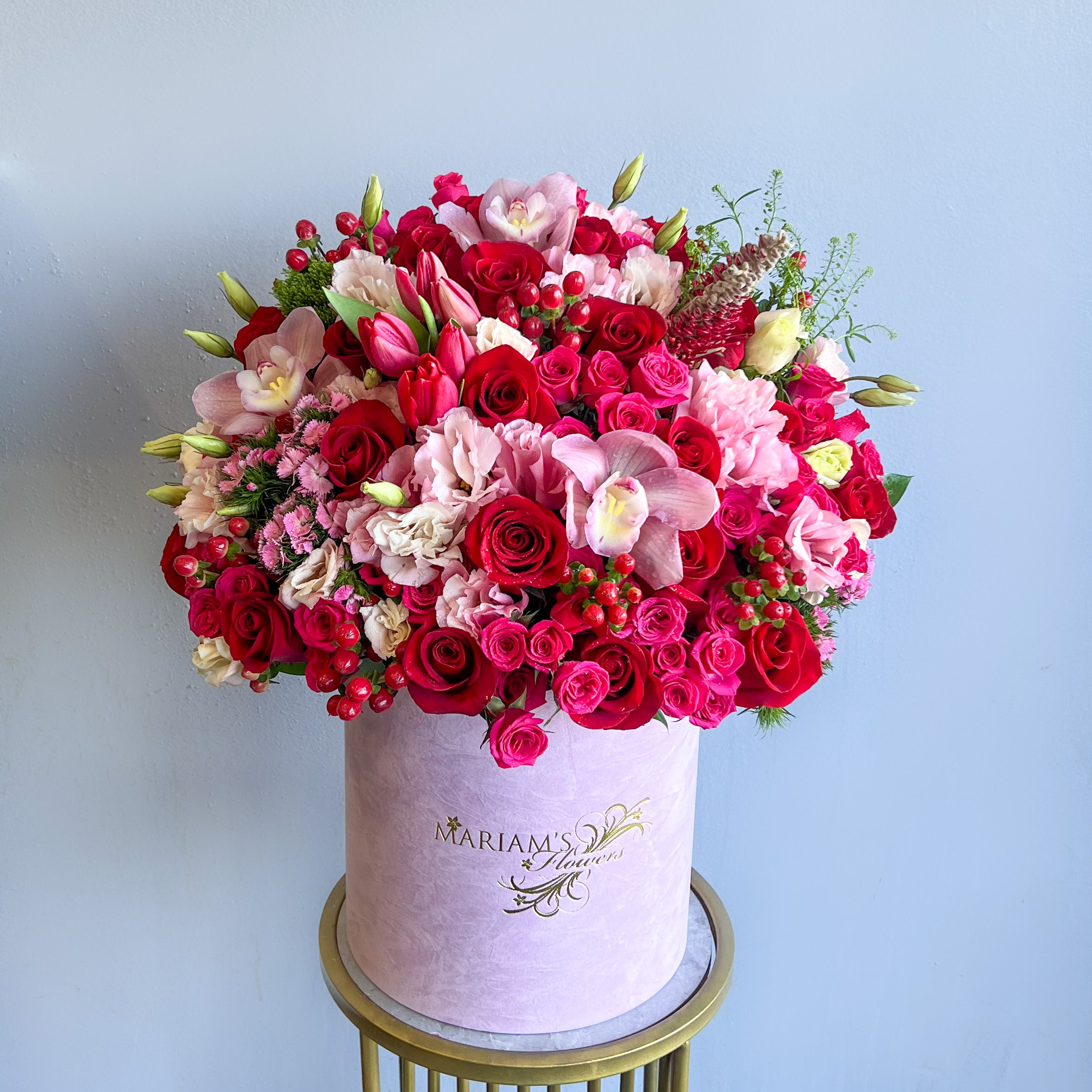 A round box filled with a beautiful pink flower arrangement, embodying the essence of springtime romance