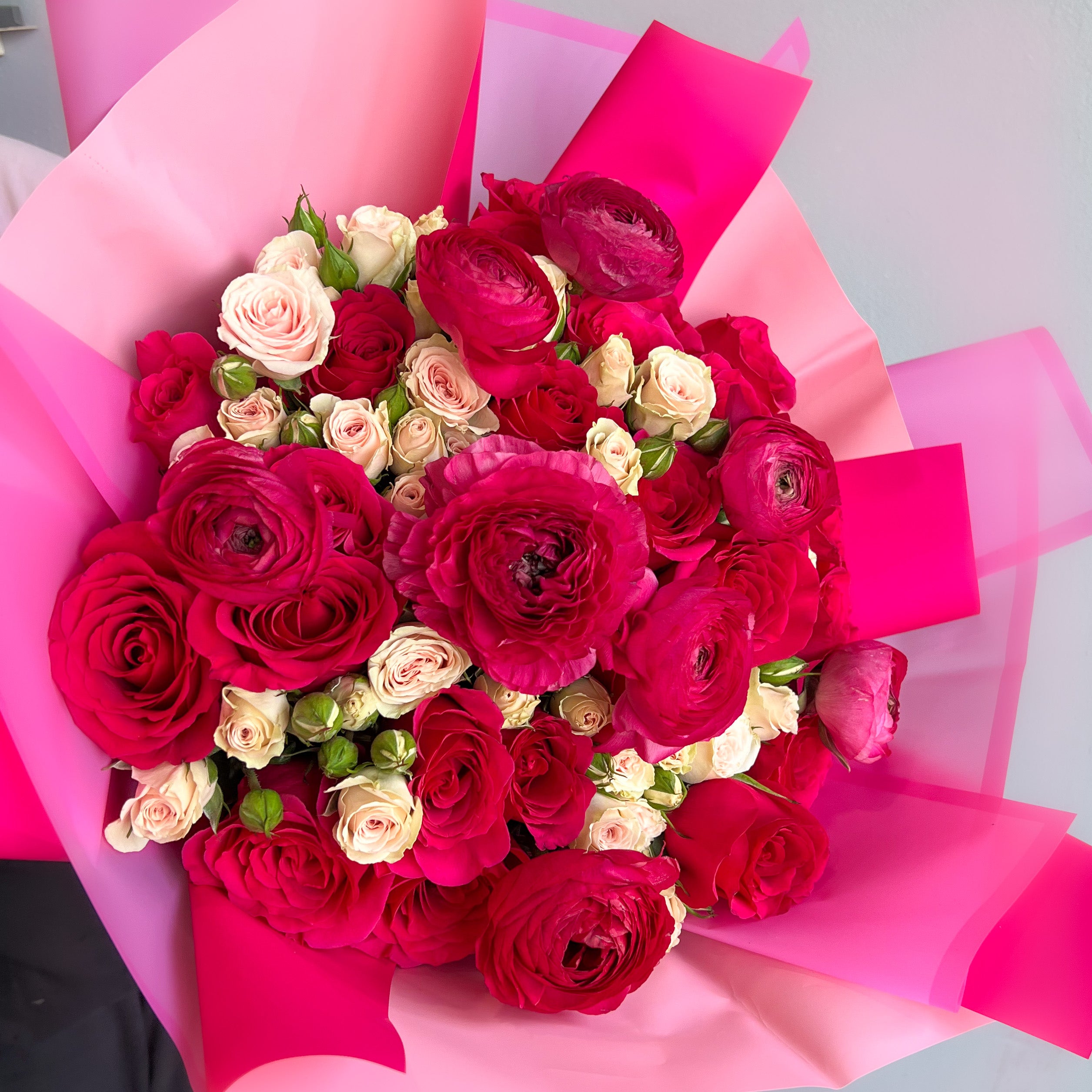 A wrapped bouquet featuring vibrant red and white roses