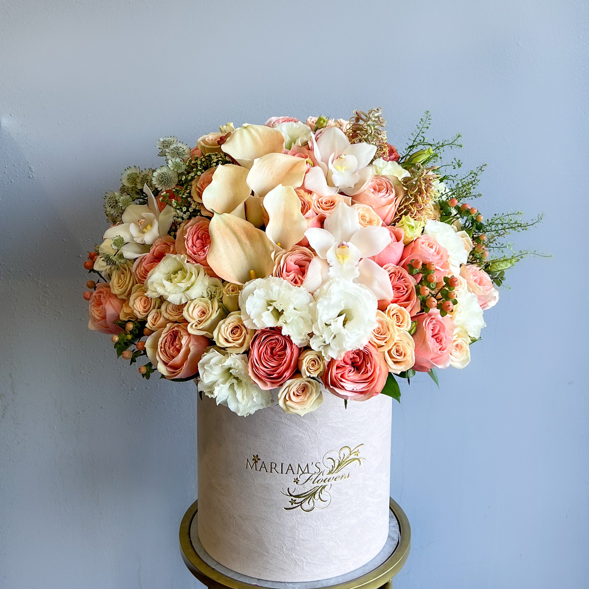 A white box filled with an arrangement of pink and white flowers, showcasing a delicate floral display